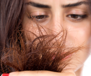 woman investigating split ends on her dark hair