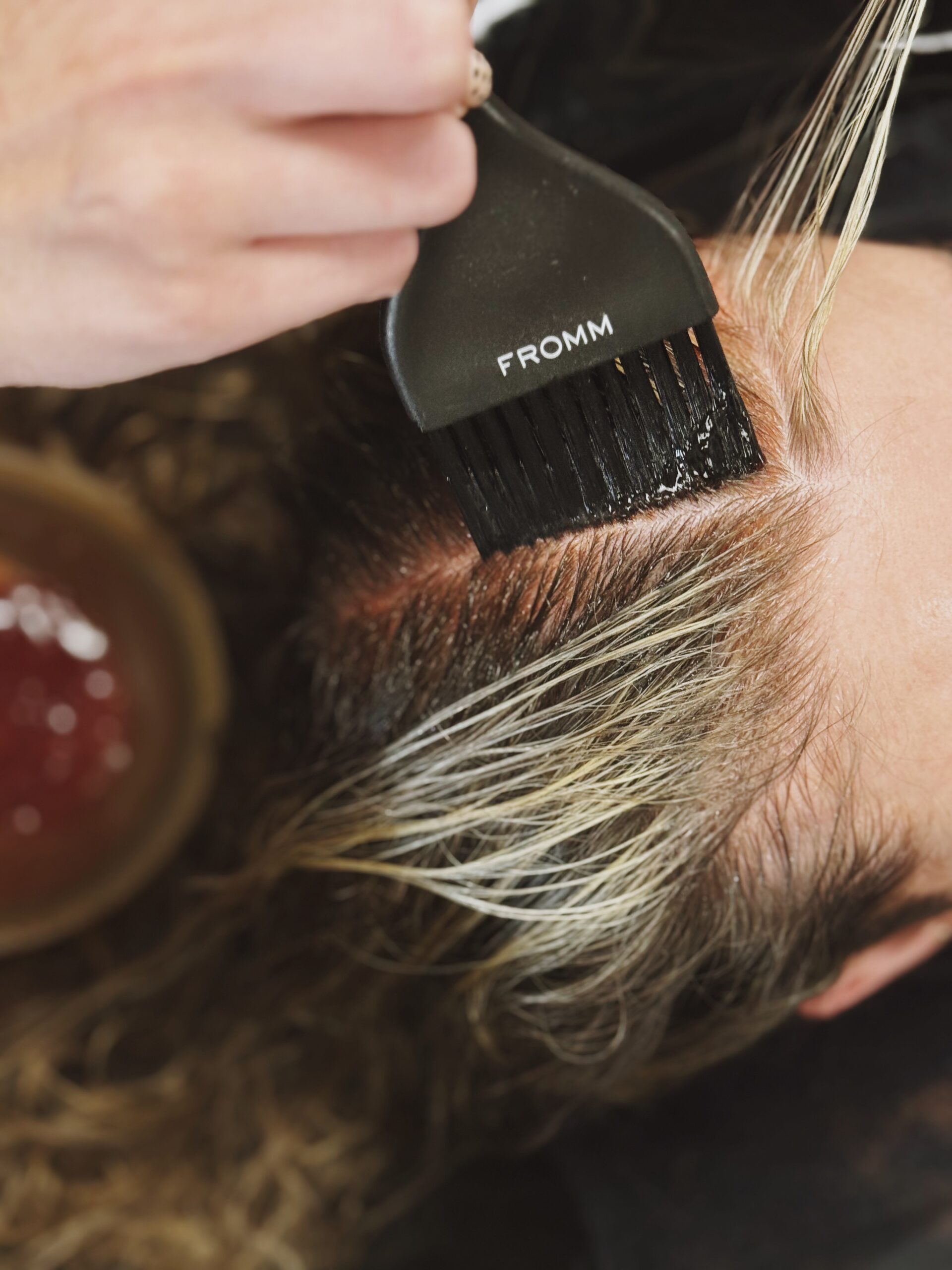 hair dresser painting clients hair using balayage technique